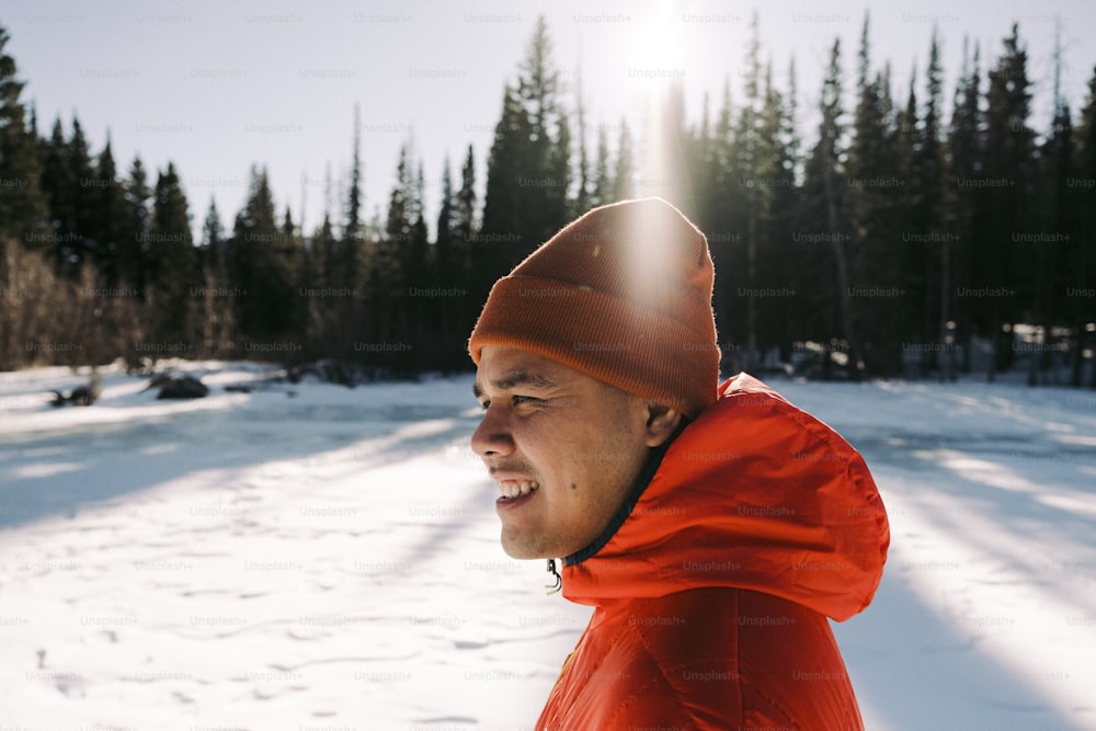 Un uomo che indossa una giacca rossa e un cappello nella neve