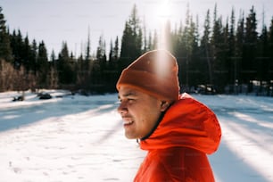 a man wearing a red jacket and a hat in the snow