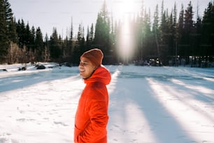 a man in an orange jacket standing in the snow