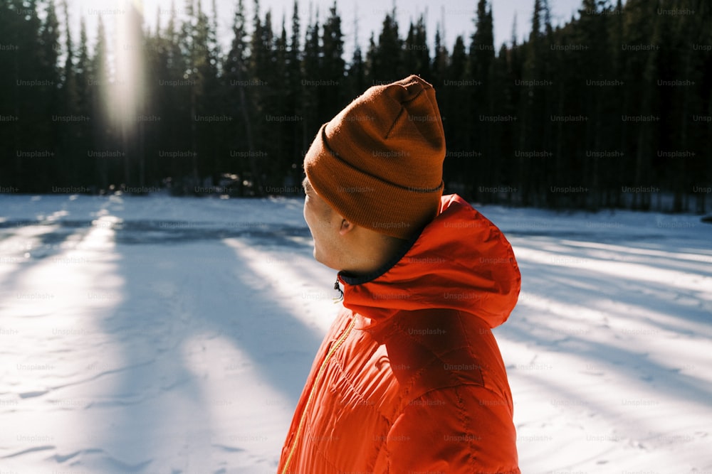 a person in an orange jacket standing in the snow