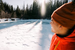 a man in an orange jacket standing in the snow