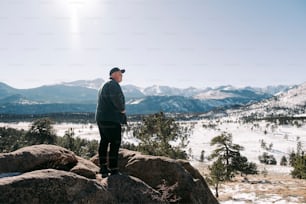 a man standing on top of a large rock