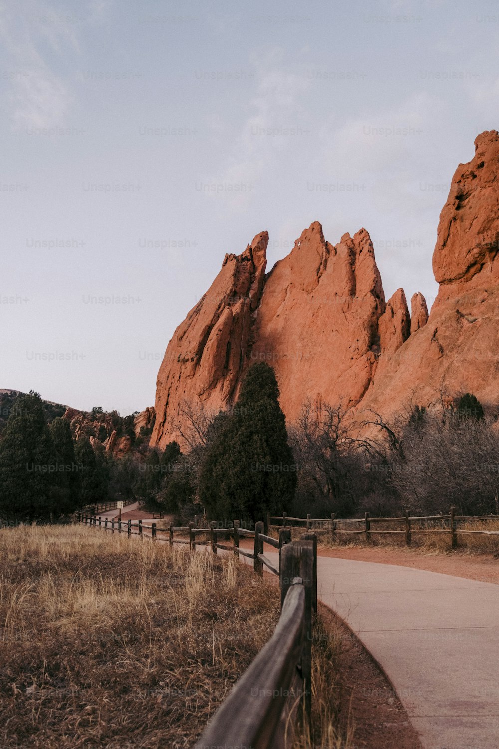 a wooden fence next to a dirt road