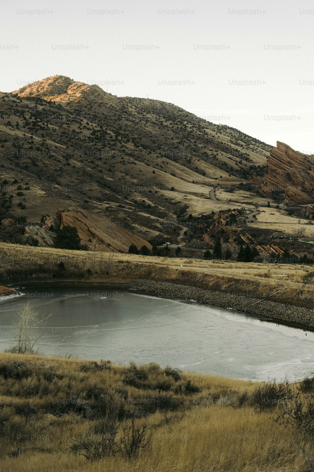 a large body of water surrounded by a lush green hillside