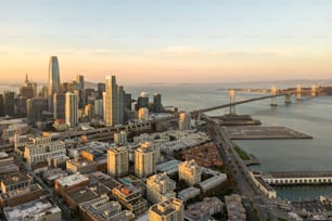 an aerial view of a city with a bridge in the background