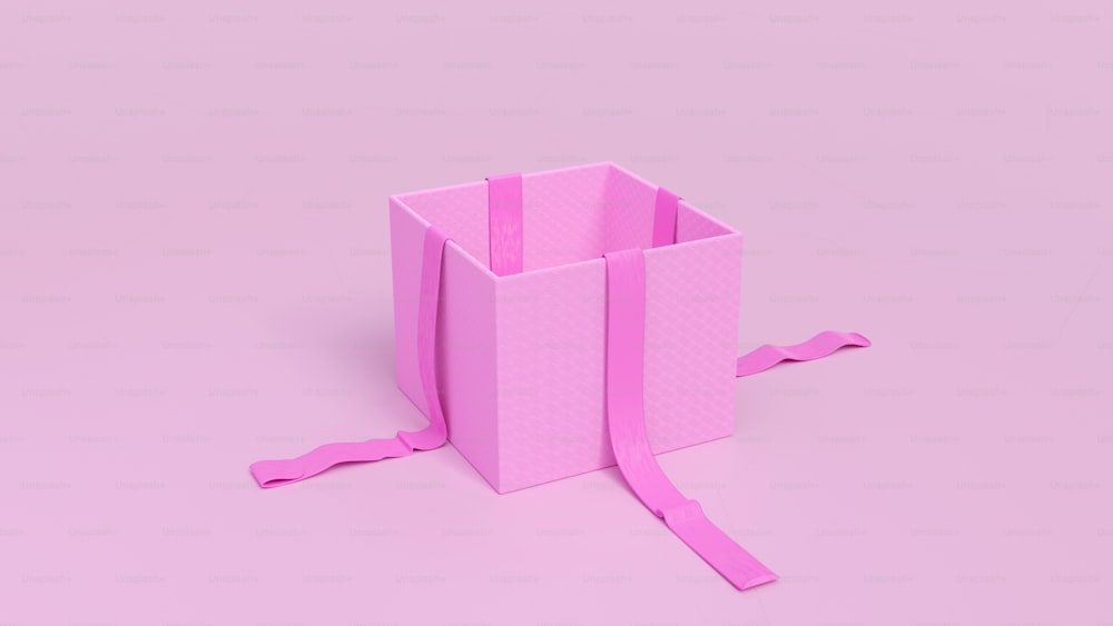 une boîte rose avec un ruban noué autour