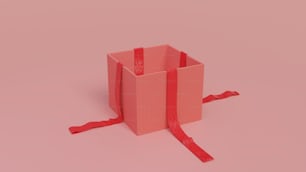 une boîte rose avec un ruban rouge noué autour