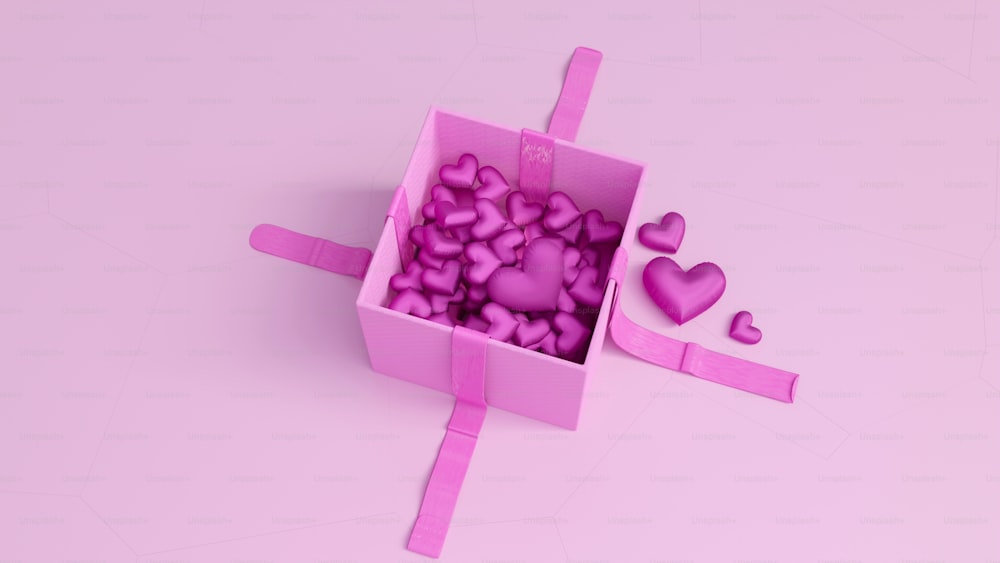 Une boîte rose remplie de beaucoup de cœurs roses