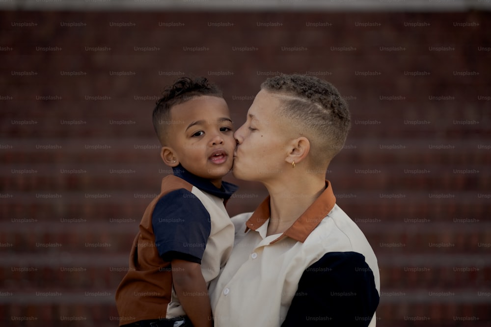 a woman kissing a young boy on the cheek