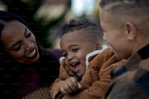 Una mujer y dos niños riendo juntos