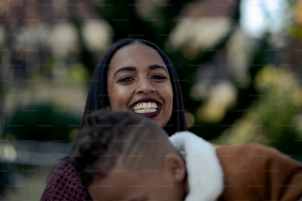 Eine Frau lächelt, während sie ein Kind hält