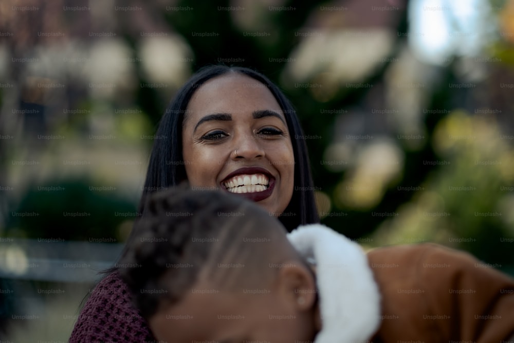 a woman smiles as she holds a child