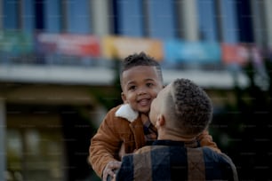 a man holding a little boy in his arms