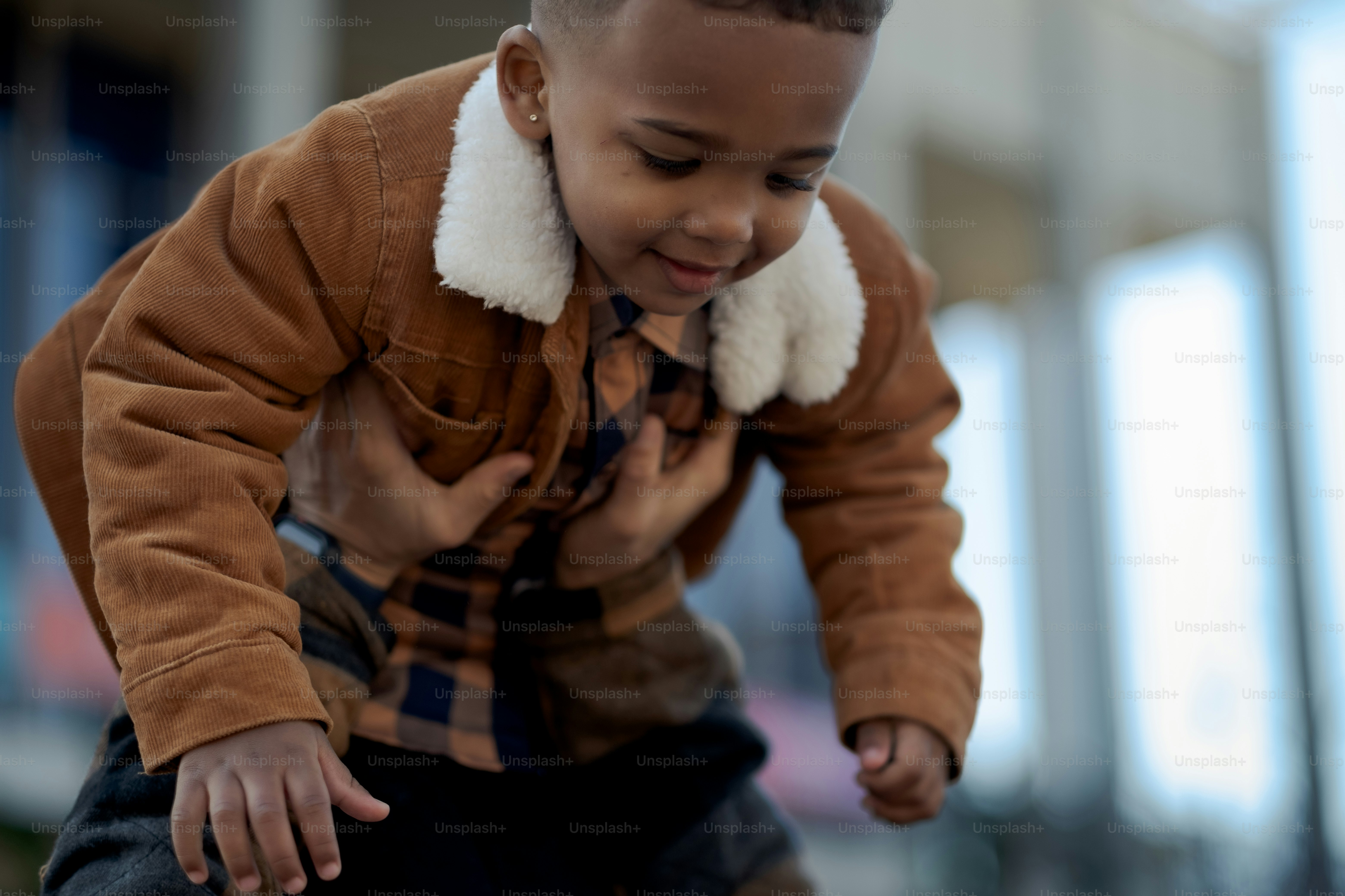 a young boy wearing a brown jacket and tie