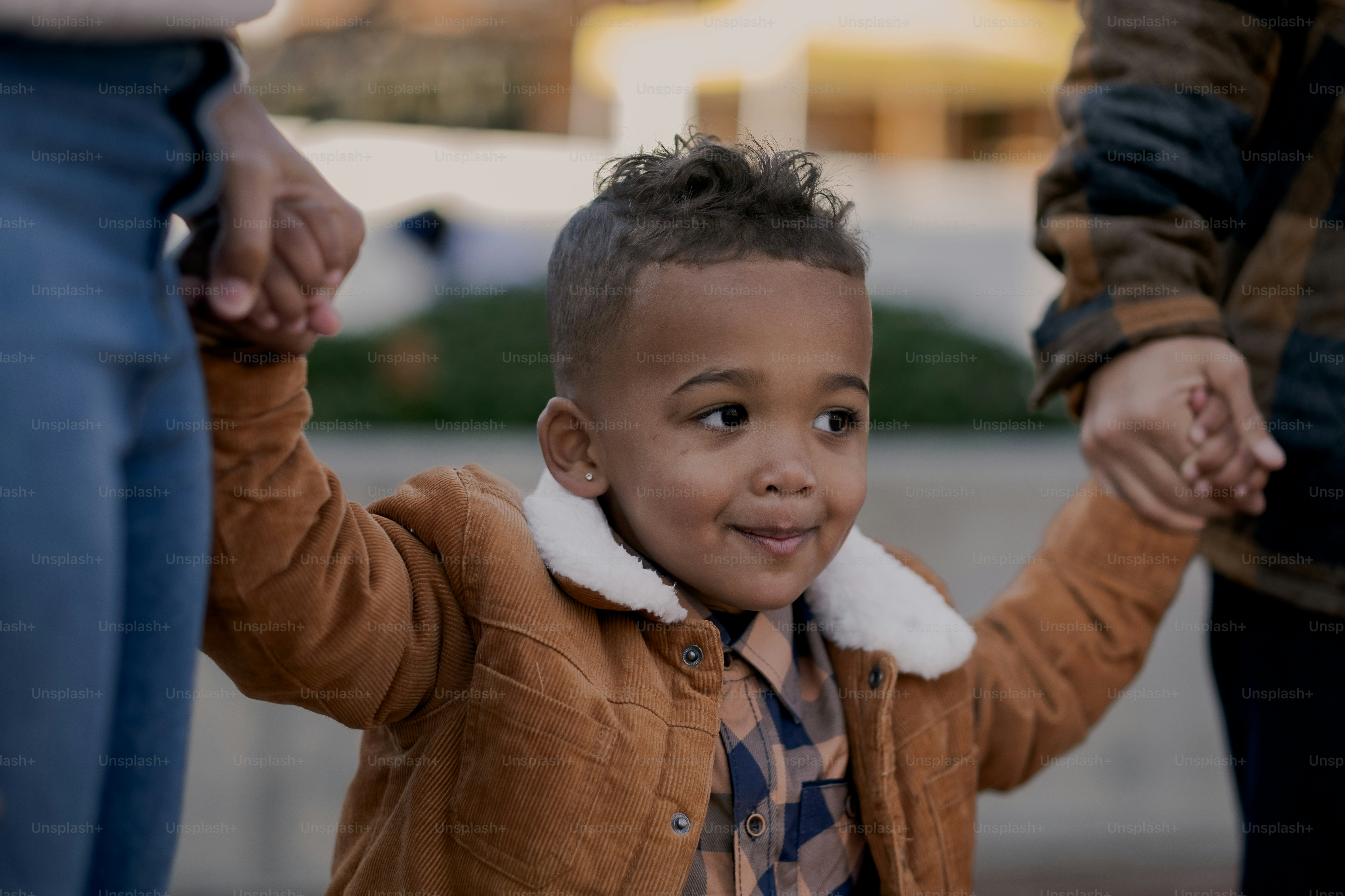 a little boy holding the hand of a woman