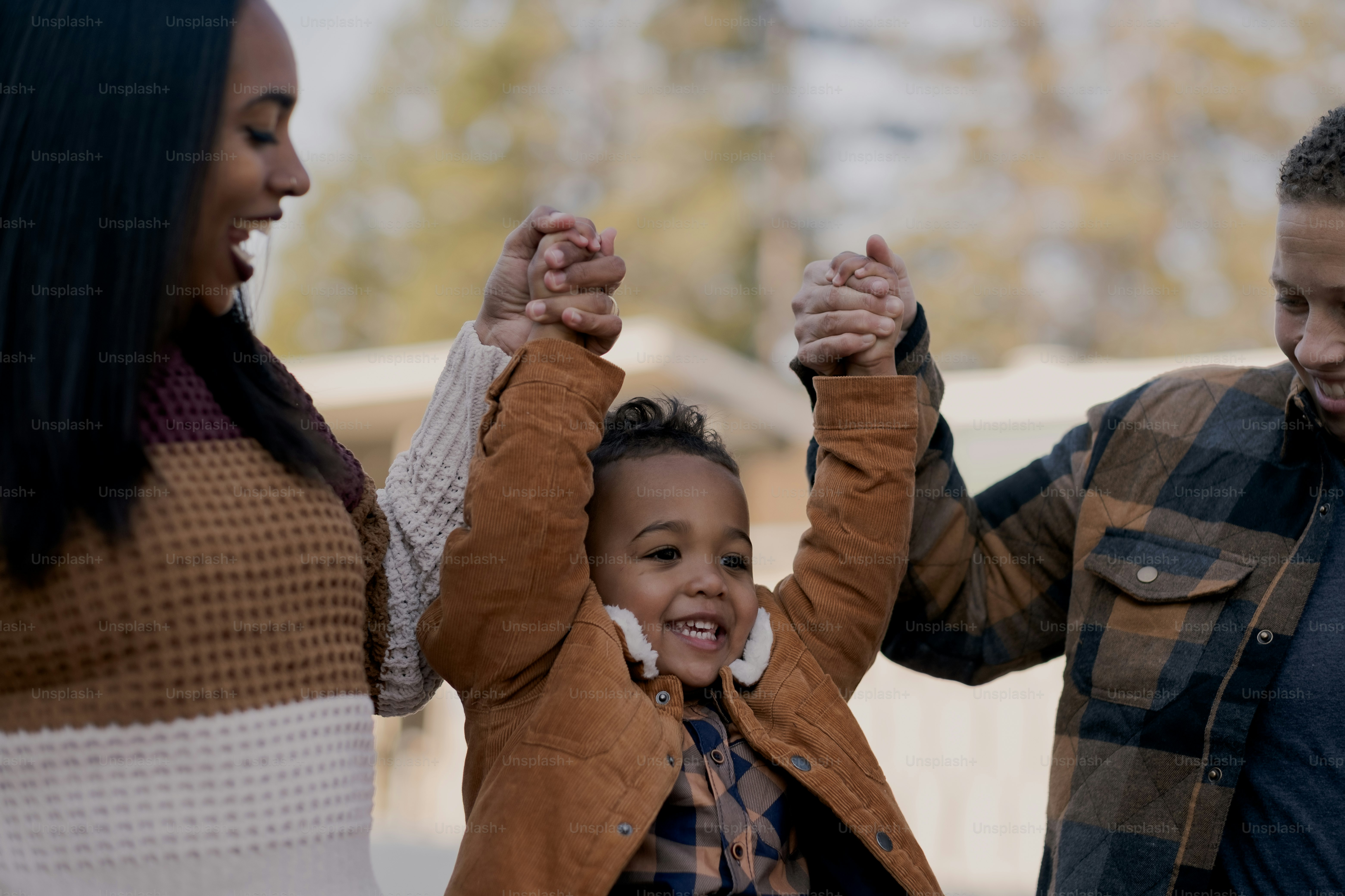 a woman and two children are holding hands