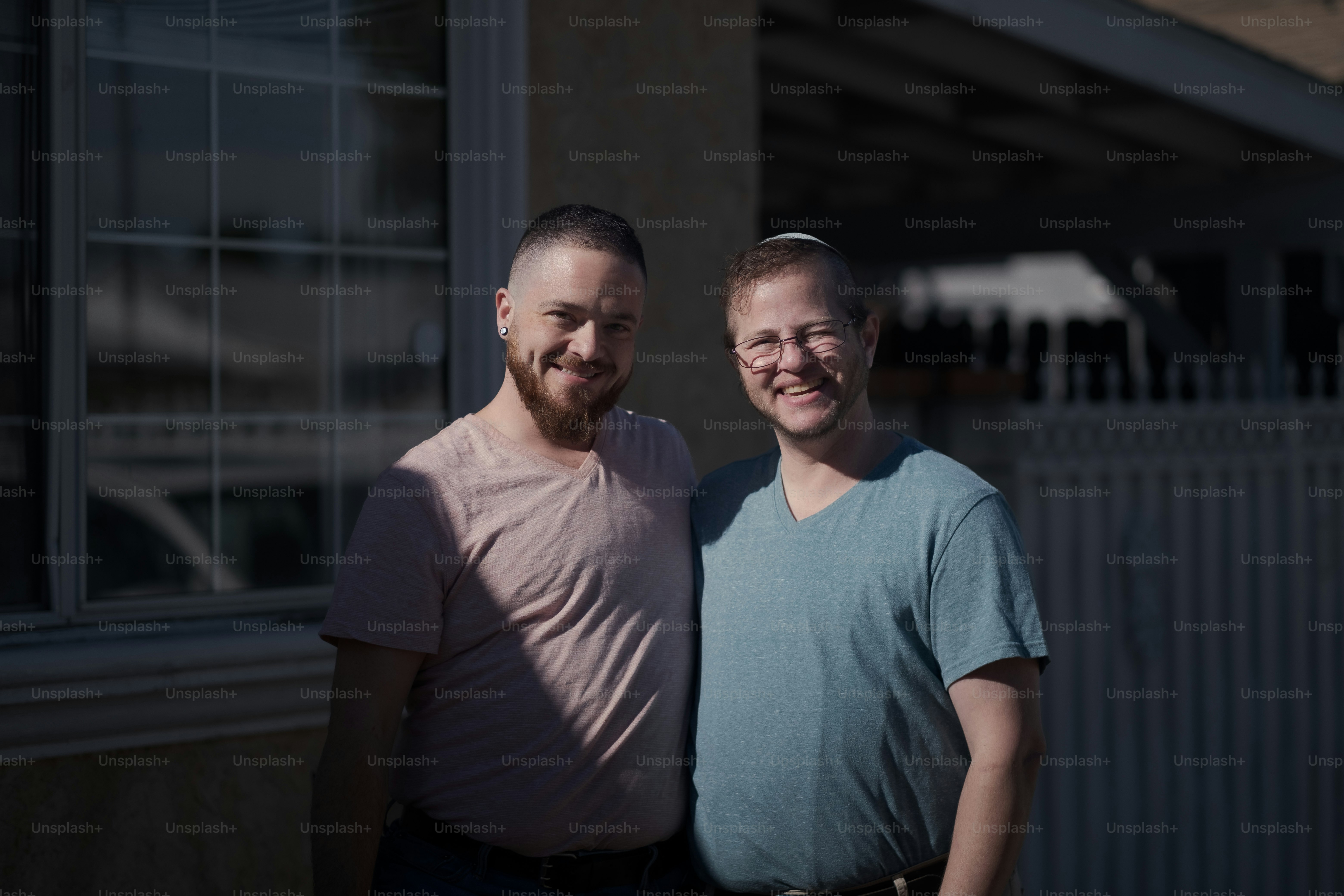 Joshua and Rafi at their home, expressing their love and affection for one other. They maintain a Jewish household for themselves and for their children. Both Joshua and Rafi are active in Jewish causes, and are men of trans experience.