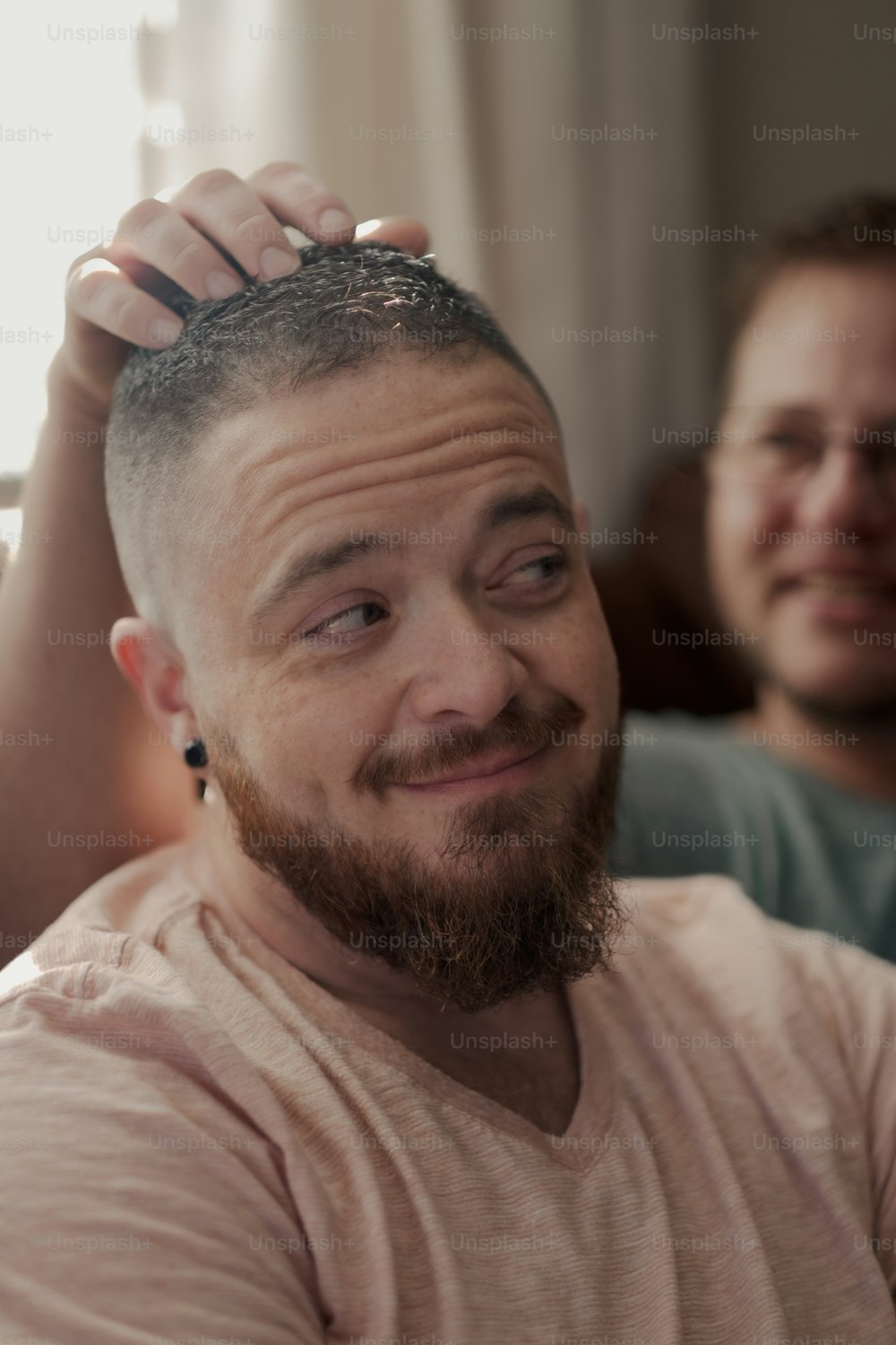 Ein Mann lässt sich von einem anderen Mann die Haare schneiden