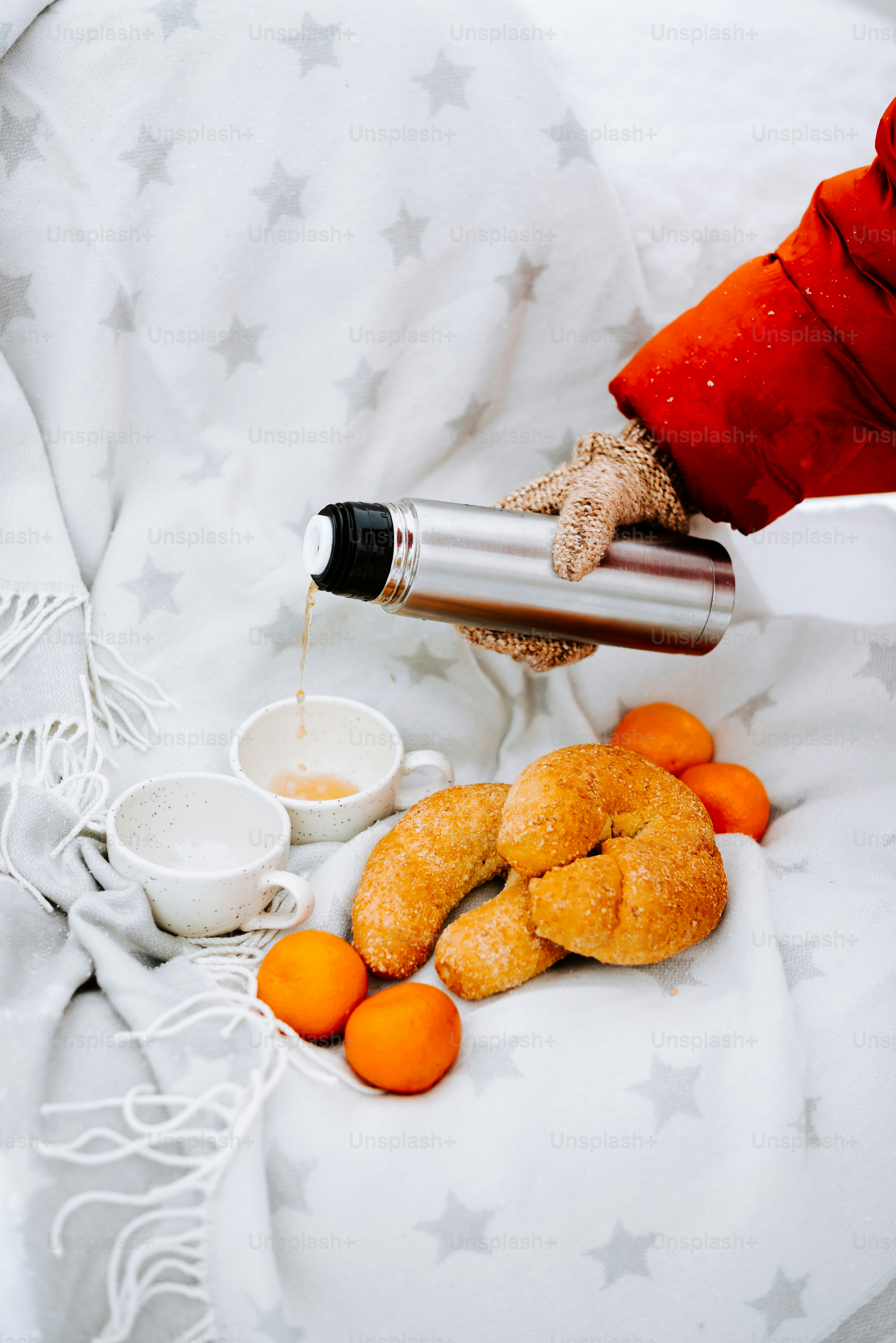 a person pouring something into a cup on top of a bed