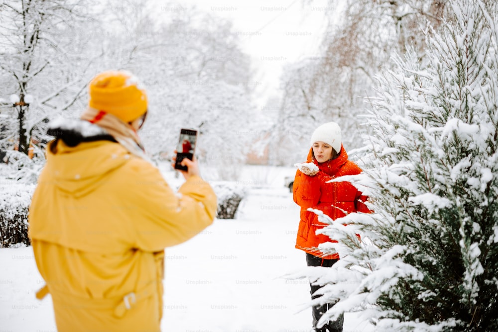 a man taking a picture of a woman in the snow