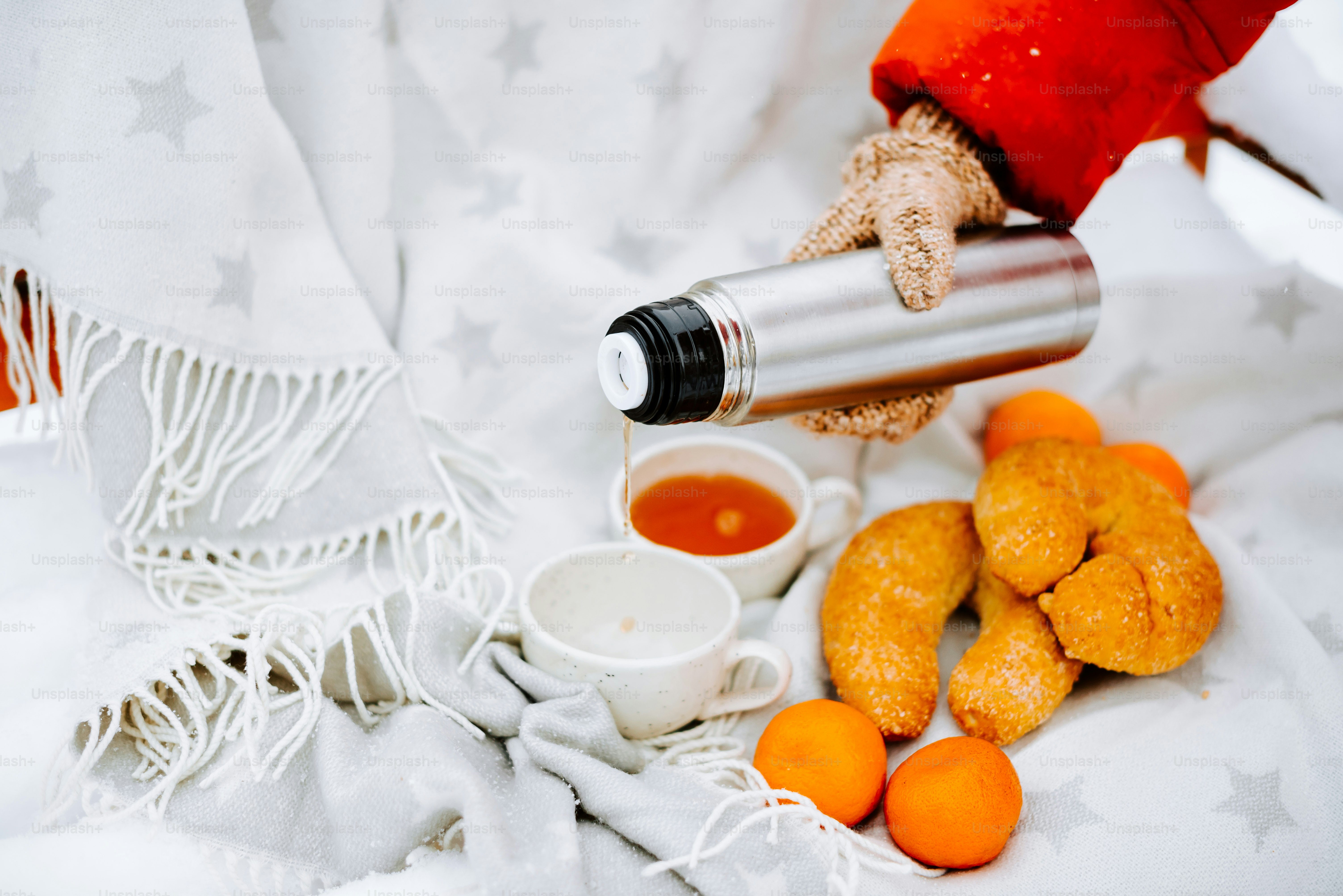 a person pouring tea into a cup on a bed