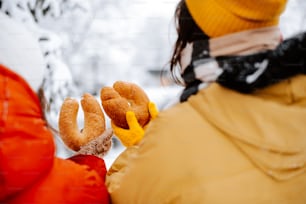 a person in a yellow jacket holding a doughnut