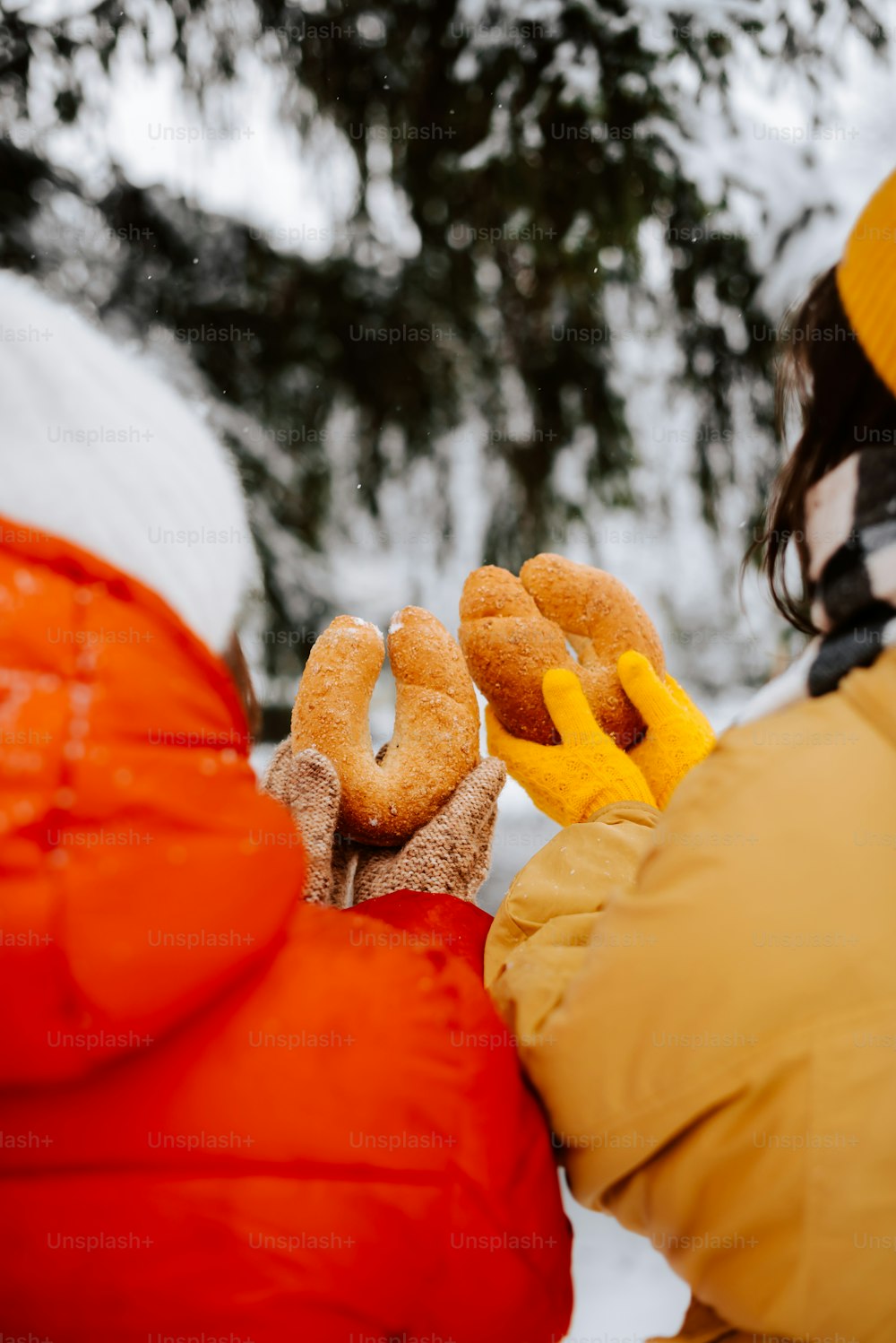 a person holding two doughnuts in their hands