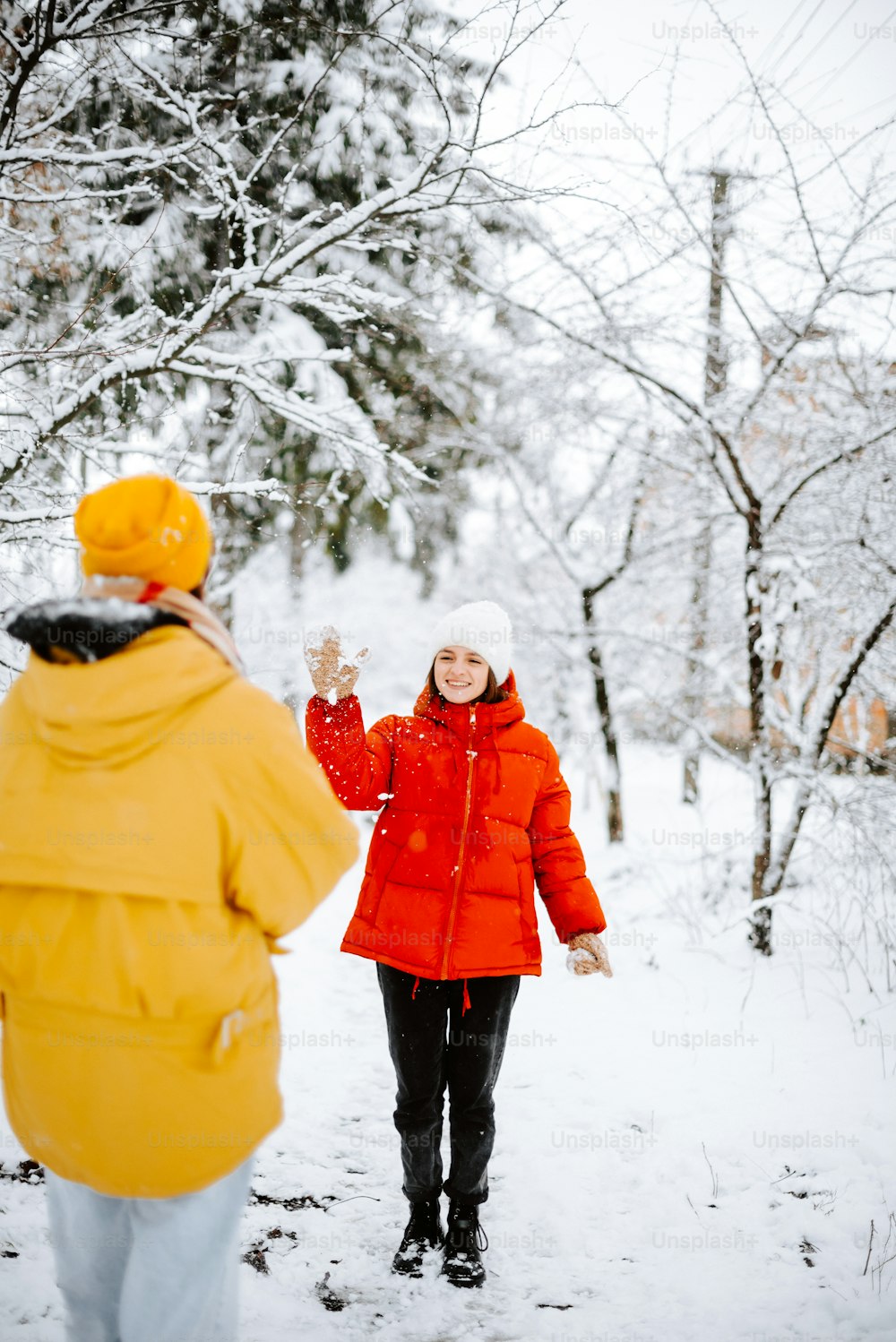 uma mulher em uma jaqueta vermelha está andando na neve