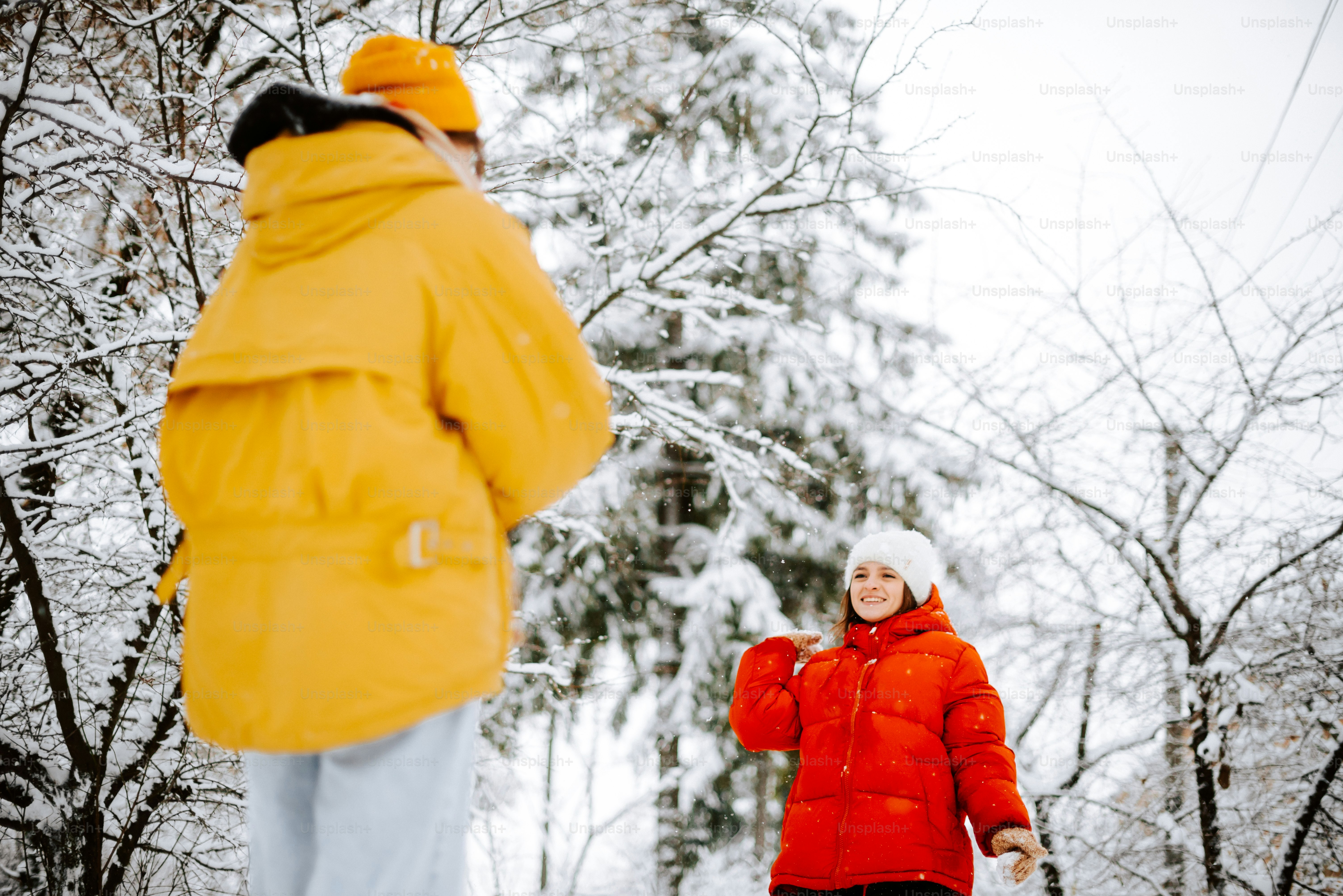 a woman in a red jacket is walking in the snow