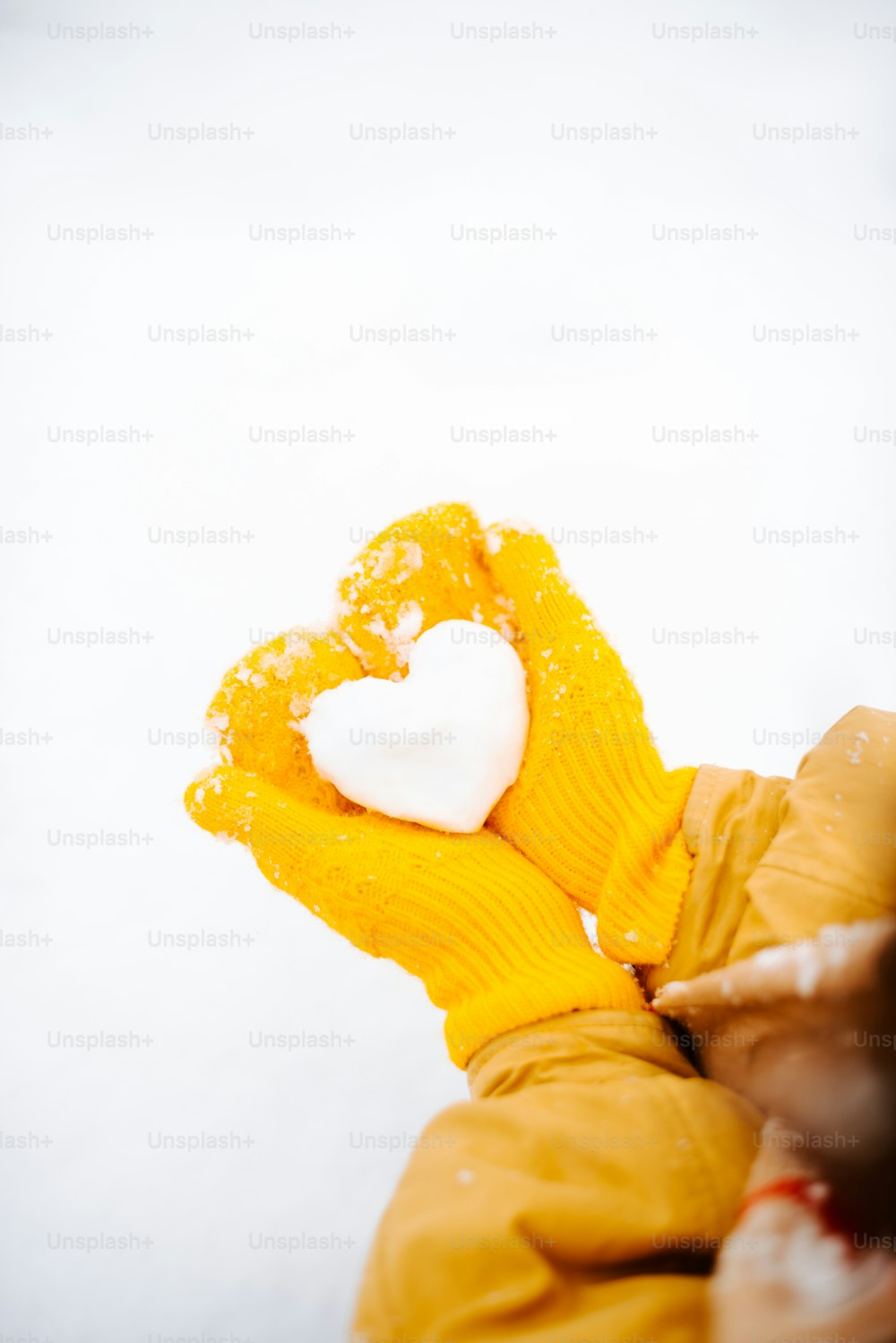 a person wearing a yellow mitt with a heart on it
