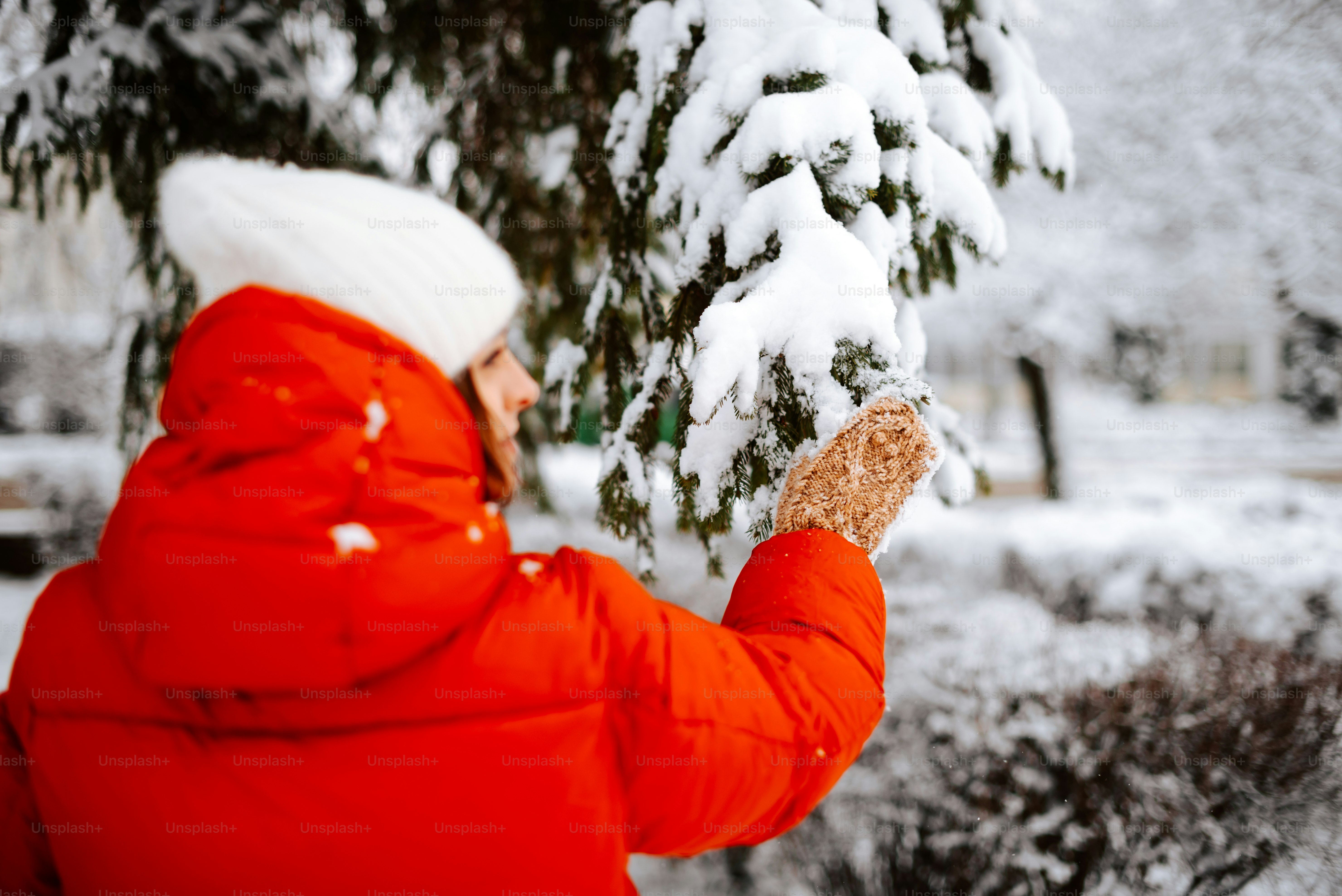 Une femme en manteau rouge tient un morceau de nourriture