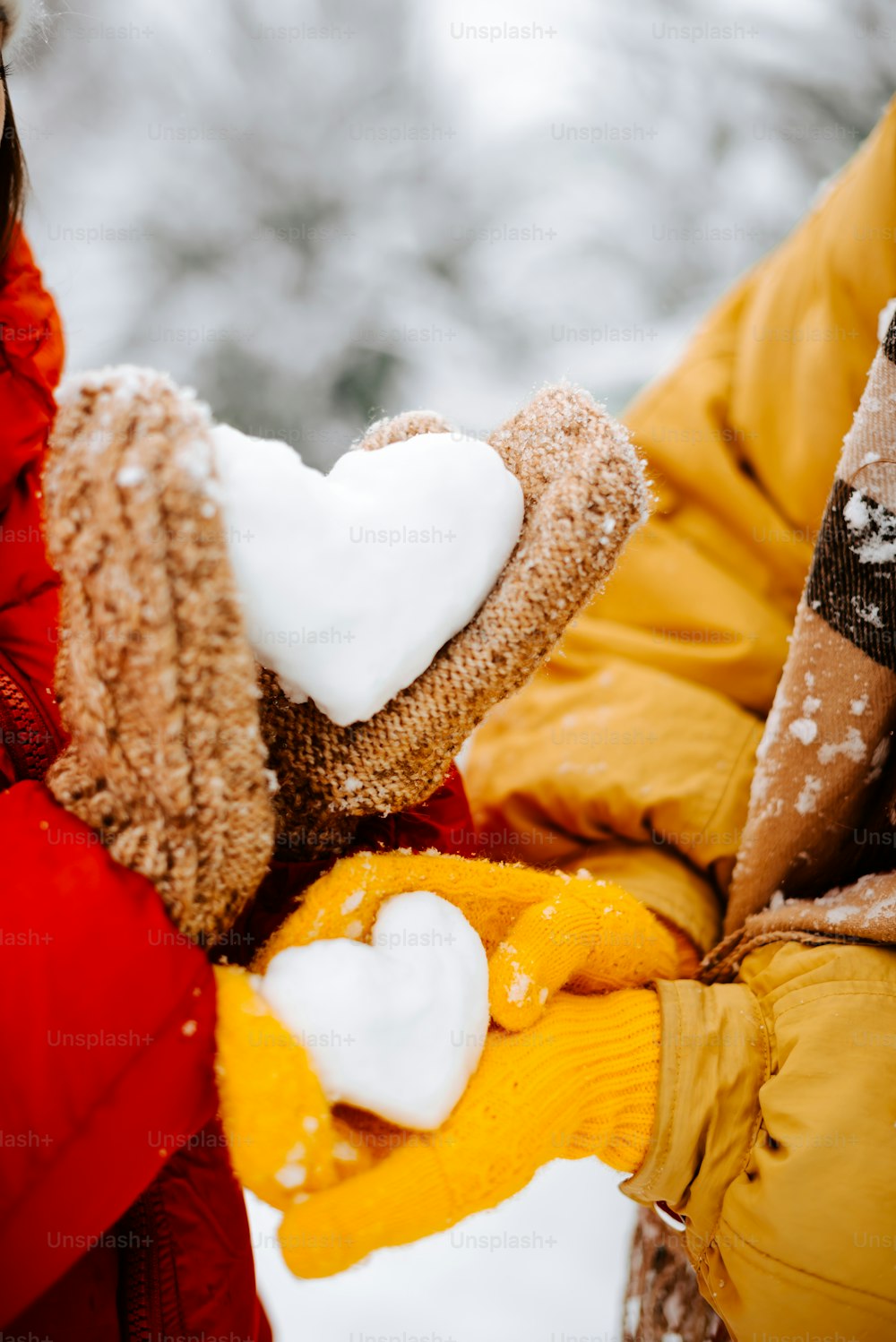 eine Person, die einen Teddybären im Schnee hält