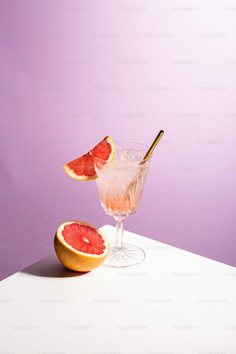 a grapefruit cocktail garnished with a gold spoon
