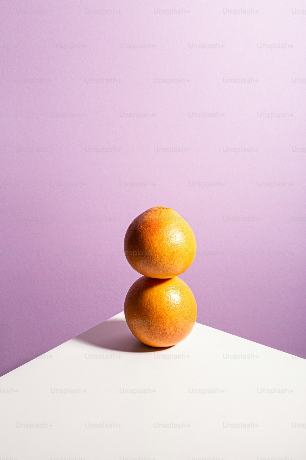 two oranges stacked on top of each other on a table