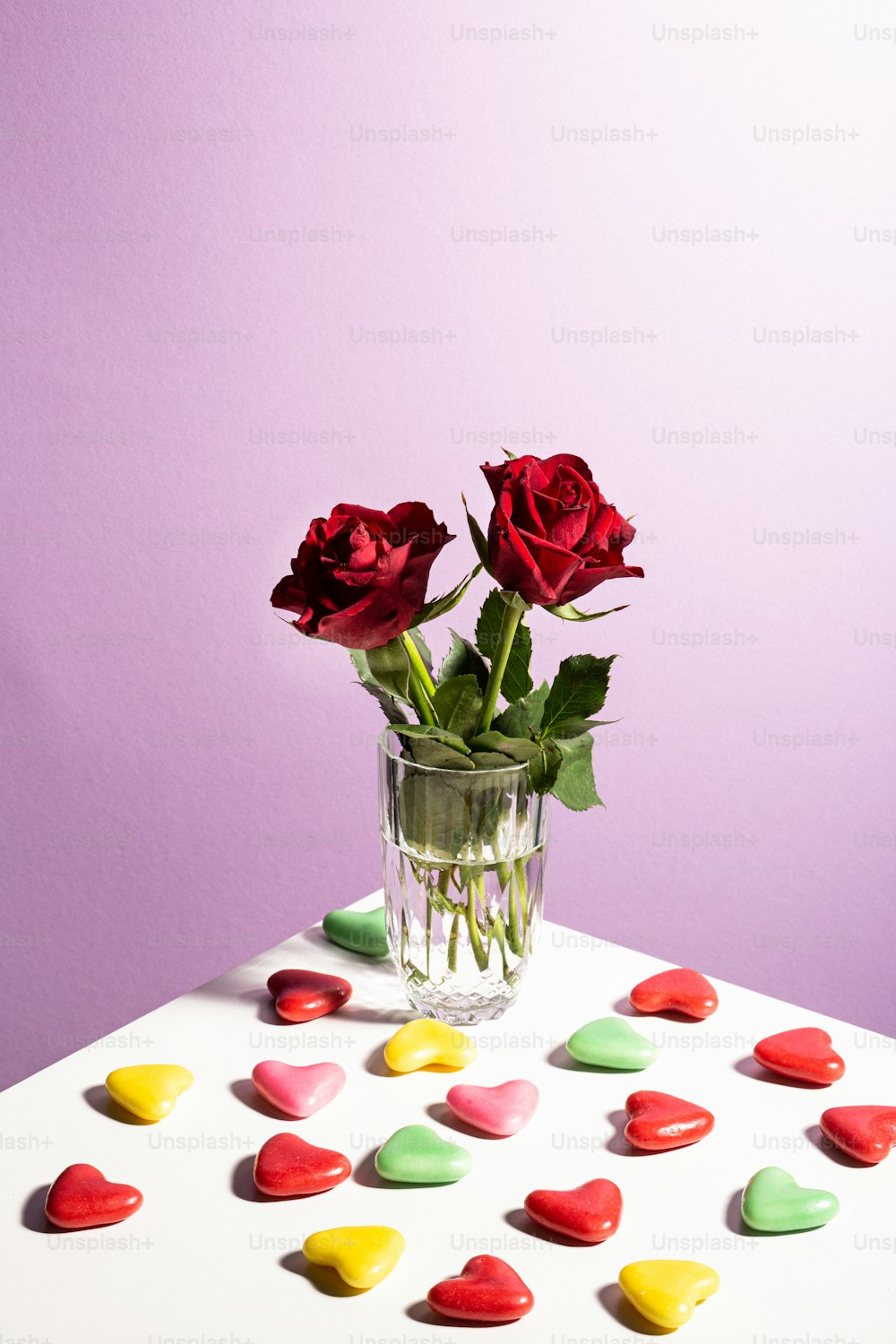 테이블 위에 앉아있는 빨간 장미로 가득 찬 꽃병