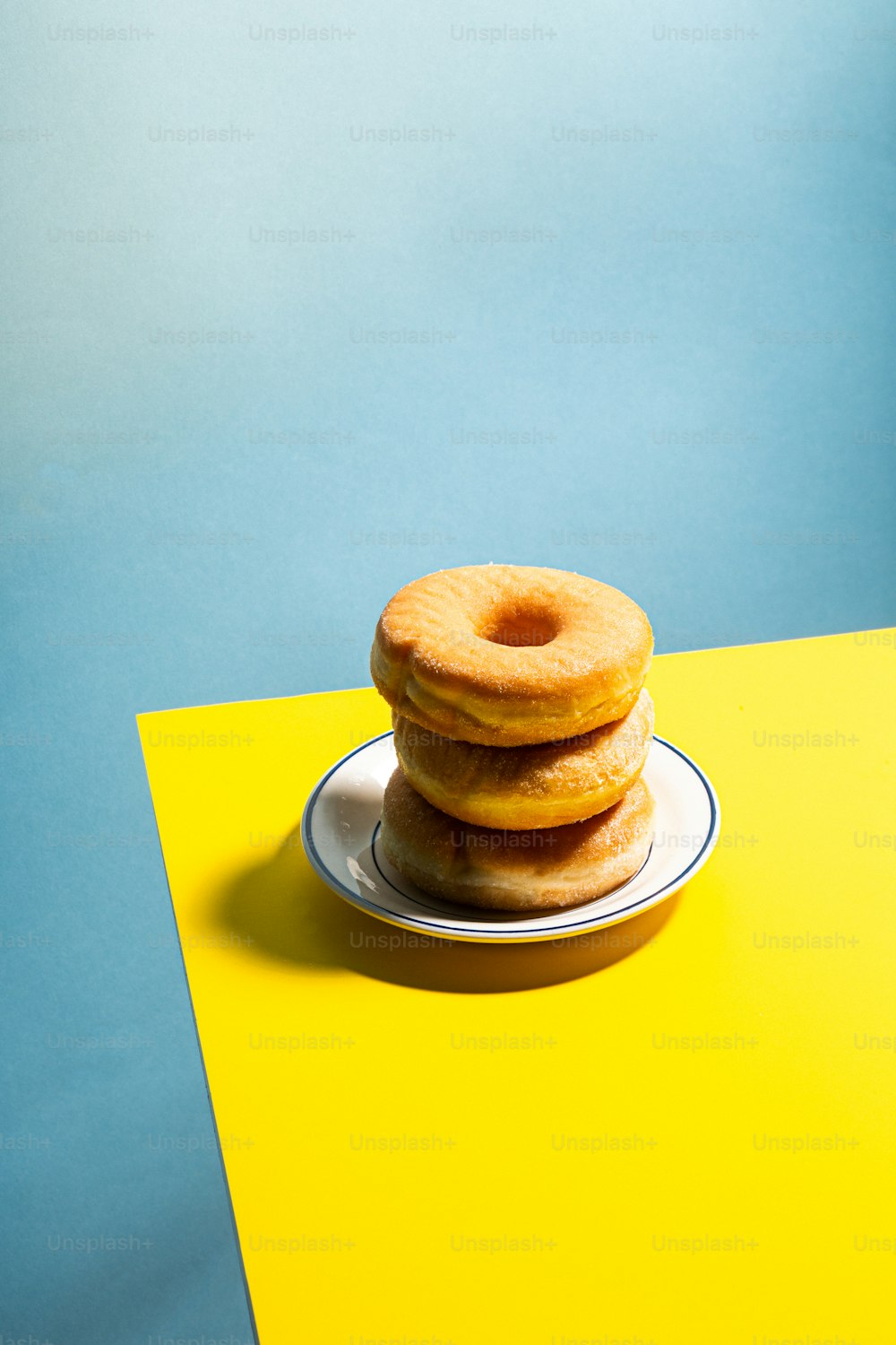 uma pilha de três donuts sentados em cima de um prato