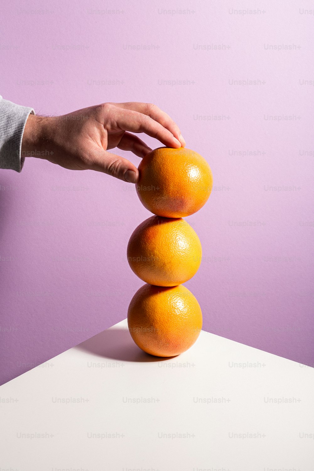 a person stacking oranges on top of each other