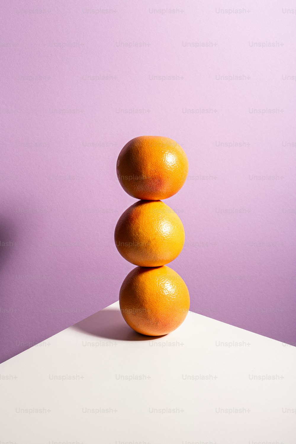 Ein Stapel Orangen sitzt auf einem weißen Tisch