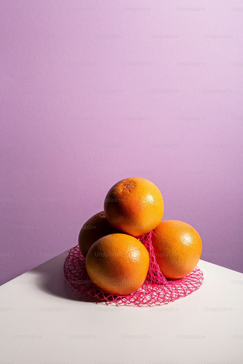 a pile of oranges sitting on top of a white table