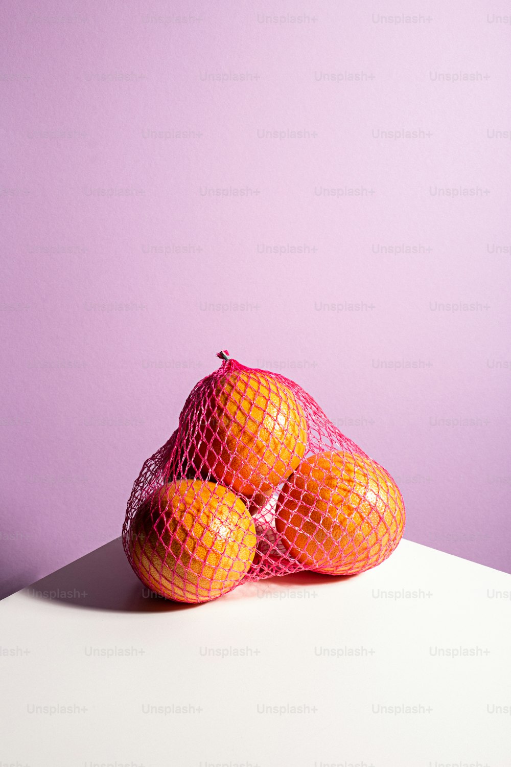 a pile of oranges sitting on top of a white table