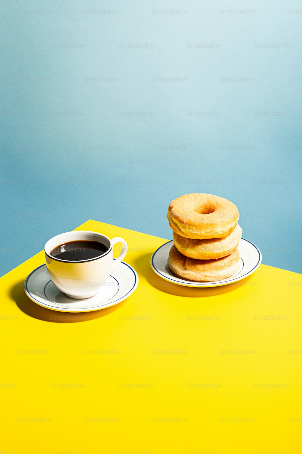 a stack of donuts sitting next to a cup of coffee