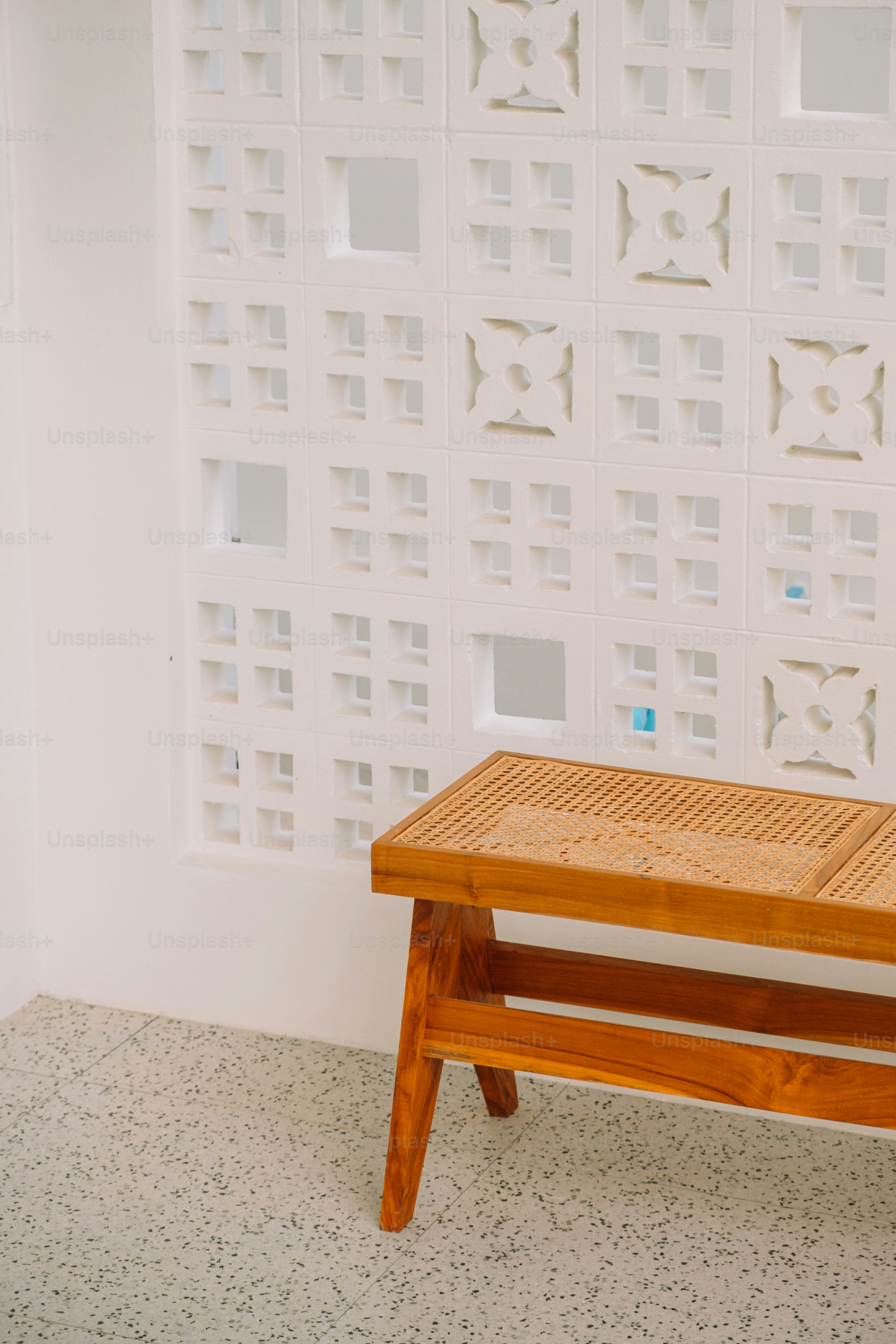 A wooden bench sitting in front of a white wall photo – Angle Image on ...