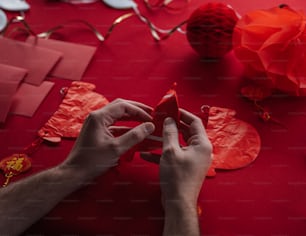 a person cutting out a piece of red paper