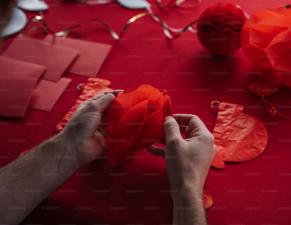 人が赤い折り紙のハートを作っている