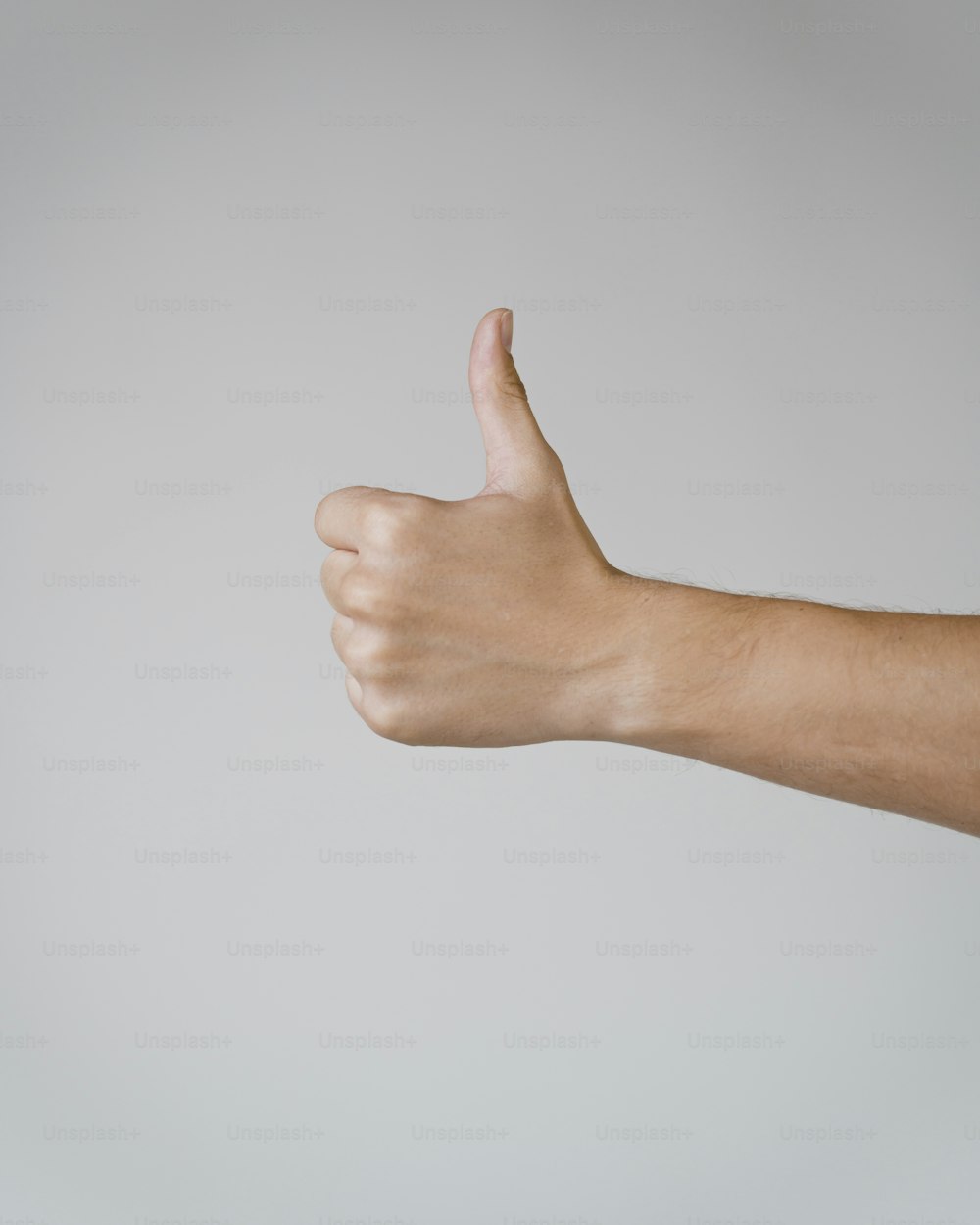 La mano de una persona haciendo una señal de pulgar hacia arriba