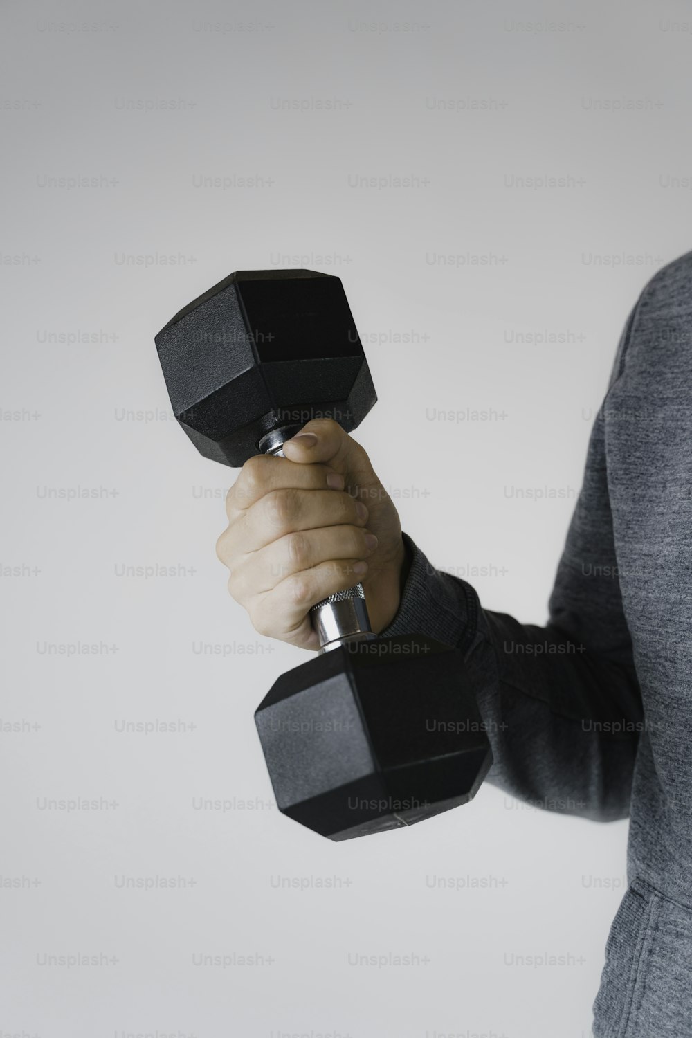 a man holding a pair of black dumbs