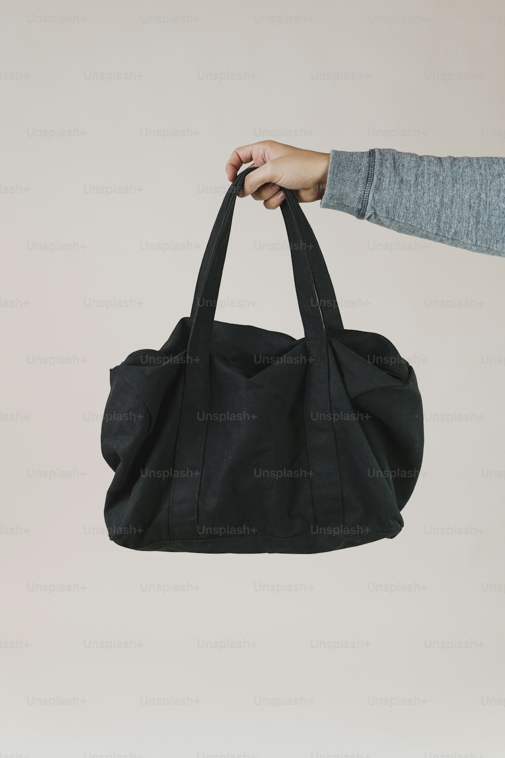a person holding a black bag in their hand