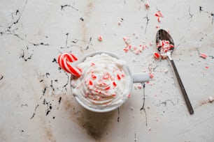 a cup of ice cream with candy canes on a table