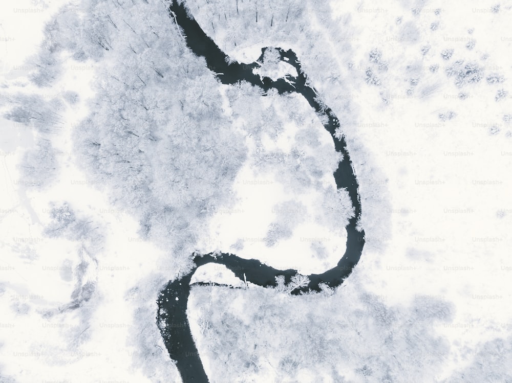 an aerial view of a river in the snow