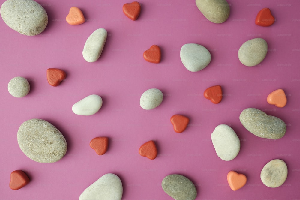 uma variedade de rochas e corações em um fundo rosa